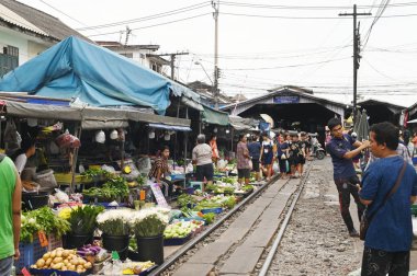 SAMUT SAKHON, THAILAND-SEPT 9, 2024: Meçhul bir satıcı Mahachai İstasyonu 'nda sebze, meyve satıyor. Tren geldiğinde, rafları yerinde bırakıyor çünkü daha aşağıda....