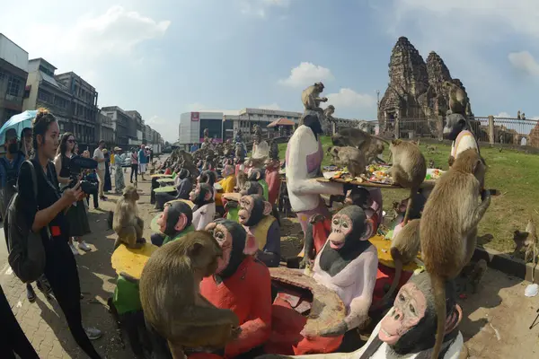 LOPBURI, THAILAND - 27 Kasım 2022: Maymunlar yerel meyve, sebze, salata, yumurta, tatlı yemeyi seviyor ki bu da insanları Phra Prang Sam Yod Tapınağı 'ndaki Maymun Partisi' nde teşekkür etmeye getiriyor..