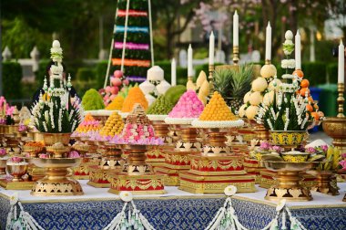 BANGKOK, THAILAND - 21 Nisan 2025: Elma, portakal, ananas, elma, üzüm, tramvay, tatlı, yapışkan pirinç keki, çiçek, Thokkathan-Mother Earth 'ün saçlarını sıkması için sunulan yemekler.