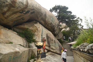 SHAANXI, ÇİN - 20 Haziran 2023: Huashan Dağı 'nda yürüyen tanımlanamayan turistler Çin' deki Beş Kutsal Dağdan biridir ve dik ve tehlikeli yolları nedeniyle dünyanın en tehlikeli dağ yollarından biridir..