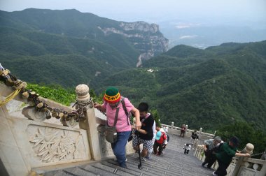 HENAN, Çin - 16 Haziran 2023: Yuntaishan Parkı 'ndaki merdivenlerde yürüyen tanımlanamayan turistler Çin' in Henan Eyaleti 'ndeki en güzel jeolojik parktır. Dünyanın ilk jeolojik miras bölgesi olarak listelenmiştir..