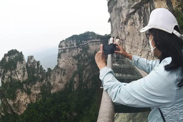 Han, Çin - 16 Haziran 2023: Kimliği belirsiz kadın turistler Yuntaishan Parkı 'nda fotoğraf çekiyorlar. Dünyanın ilk jeolojik miras bölgesi olarak listelenmiştir..