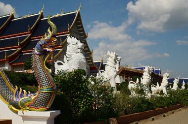 Tayland sanatında hayvan olan Naga ve Singha heykelleri, Wat Den Sali Mueang Kaen tapınağındaki ibadet salonu ve şapelin önünü dekore eder. Tayland 'ın Cheng Mai şehrinde yer almaktadır..