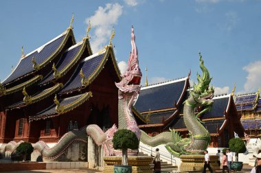 CHENG MAI m THAILAND - 1 Ocak 2025: Tayland 'da Naga heykellerinin renginde turistlerin tanımlanamaması Wat Den Sali Mueang Kaen tapınağındaki ibadet salonunun basamaklarını süslüyor. Tayland 'ın Cheng Mai şehrinde yer almaktadır..