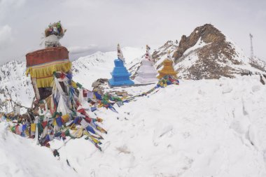 Khardung La 'da küçük bir dini sitede dua bayrağı. Bu geçit Leh 'in kuzeyindeki Ladakh dağlarında yer almakta ve Indus ve Shyok nehir vadilerini birbirine bağlamaktadır..