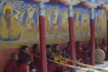 LEH, INDIA - Mayıs 2019: Kültürel açıdan zengin, ruhani ve adanmış bir atmosferde düzenlenen ruhani tören sırasında geleneksel Tibet boynuzu veya Dangchen enstrümanının bir parçası olarak Budist bir keşiş grubu. 
