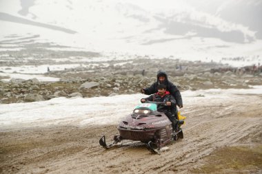 JAMMU AND KASHMIR, INDIA - MAY 10, 2019 : Unidentified of local Kashmiri and tourists driving snowmobile in winter seasona at Gulmarg , It is one of the best ski resorts in Asia, is hailed as the 