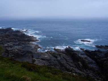 Okyanus dalgaları engebeli kayalıklara çarpar