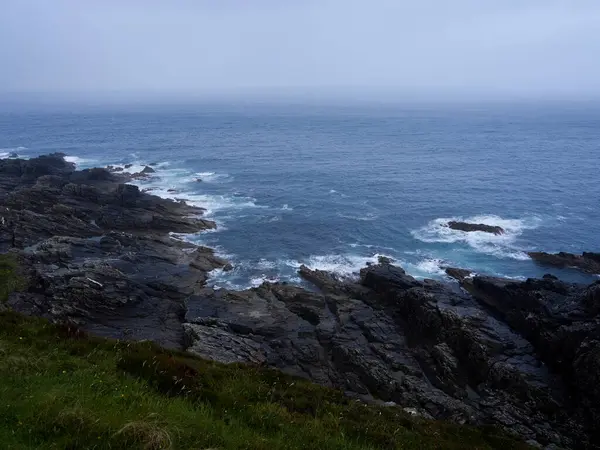 Okyanus dalgaları engebeli kayalıklara çarpar