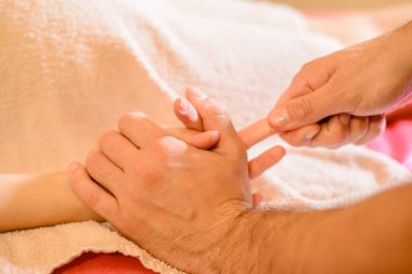 Masör ellerindeki yağ ile masaj yapar.