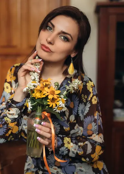 Neşeli bir kadın renkli bir buket tutar, sıcak dekorlu sıcak bir iç mekanda mutluluk saçar.