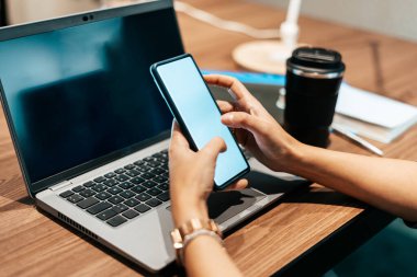 Ofisteki kadın akıllı telefonunu kullanıyor.