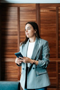 Ofisteki kadın akıllı telefonunu kullanıyor.
