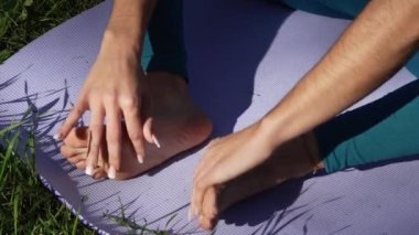 Yoga minderinde kızın ayakları doğayla iç içe.