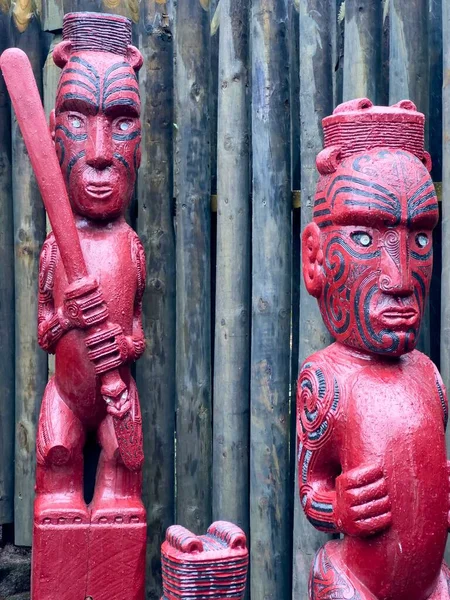 Wood carved Maori statues of warriors in garden.
