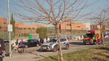 Madrid, İspanya, Sanchinarro 10 K, 01-19-2025: Maratondan önce bacaklarını açan genç kadın, sağlık görevlileri ve polis bölgeyi güvenlik altına alıyor