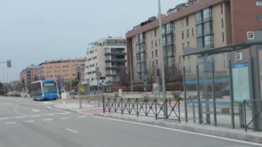 Madrid, İspanya, 01 / 29 / 2025, Transporte urbano: Şehir ortamında park halindeki arabalar ve yeşil alanlarla çevrili ağaçlık bir bisiklet yolunun sergilendiği sakin kentsel manzara