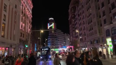 Madrid, İspanya, Cityscape, 02-03-2025: Geceleri aydınlanmış Capitol binası, arabaları ve yayaları ile kalabalık Gran Va caddesi