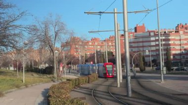 Madrid, İspanya, Sanchinarro, 02-05-2025: Bir yerleşim bölgesine gelen ve giden kırmızı tramvay