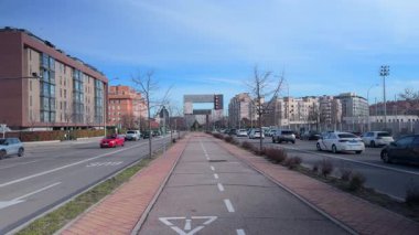 Madrid, İspanya, Cityscape, 02-27-2025: Güneşli bir günde arka planda selvi ağaçları ve binalarla dolu bir geçit