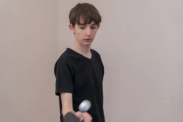 Ping pong oynayan genç bir adam, antrenman yaparken ve egzersiz yaparken forehand becerilerini geliştiriyor. Parlak, davetkar bir yerde.