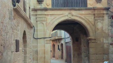 Taş kemer ve ahşap balkon Kretas, Matarraa Bölgesi, Teruel Bölgesi, İspanya 'da pitoresk bir ara sokakta.