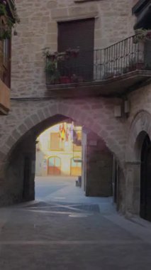Güneşli Kretas 'ta tarihi taş kemer boyunca pedal çeviren yalnız bisikletçi, geleneksel İspanyol köyü mimarisini ve manzaralı sabah ışığını yakalıyor.