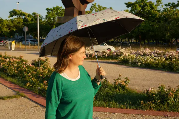 Şarj istasyonunda şarj kablosunu sarı elektrikli araca bağlayan ellerin yakın çekimi sürdürülebilir ulaşımı gösteriyor