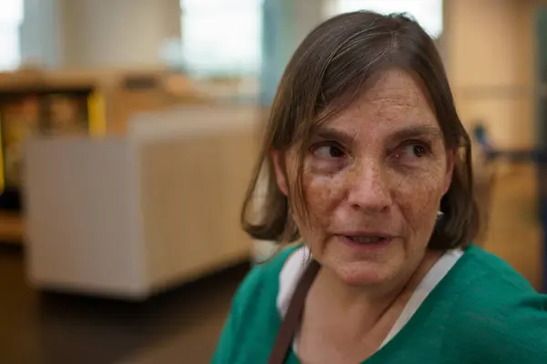 Şarj istasyonunda şarj kablosunu sarı elektrikli araca bağlayan ellerin yakın çekimi sürdürülebilir ulaşımı gösteriyor