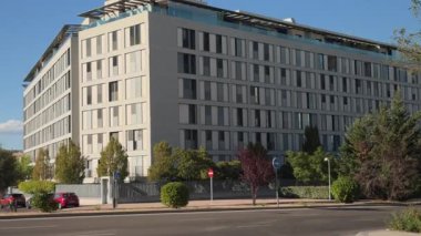 Çağdaş ofis binası park alanı ve caddenin yanında, Madrid şehir merkezinde modern mimari tasarımı güneşli gökyüzü altında sergileniyor.