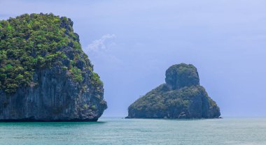 Yağmur mevsiminde, Tayland 'da Mu Ko Ang Tanga Ulusal Parkı' nda iki kayalık ada, gökyüzü ve bulutlar yağmur yağacağını tahmin ediyor. Kaya dokusu, yemyeşil yeşillik ve turkuaz, durgun su.