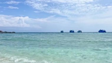 Tayland, Koh Tao yakınlarındaki Nang Yuan Adası 'nın kumlu kıyılarına demir atmış gemiler. Turkuaz sularda sallanan tekneler gibi yumuşak dalgalar sahili kaplıyor. Berrak denizi ve pitoresk manzarasıyla huzurlu ve davetkar bir ada..