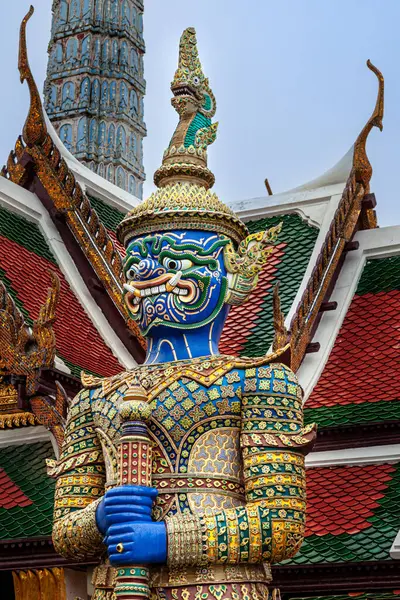 Bangkok 'ta Wat Phra Kaew' in girişinde, Yaksha olarak bilinen canlı ve ayrıntılı bir koruyucu heykel duruyor. Heykel, altın başlık ve aksesuarlarla süslenmiş, cesur görünümlü mavi bir yüze sahip..