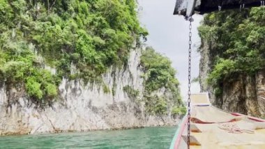 Sersemletici yeşil uçurumlar ve berrak sularla çevrili bir tekne yolculuğunun huzurunu yaşayın. Bu pitoresk manzara Tayland 'ın Khao Sok manzaralarının güzelliğini yansıtıyor, doğa severler ve maceracılar için mükemmel..