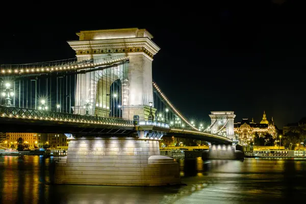 Budapeşte 'deki ikonik Zincir Köprüsü mimari zarafetini sergileyerek gece güzelce aydınlatıldı. Tuna Nehri ışıkları yansıtarak şehirde çarpıcı ve romantik bir ortam yaratıyor..