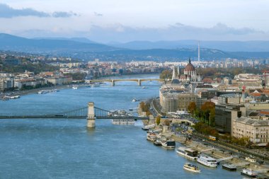 Bu resim sahnesi Budapeşte 'de akan Tuna Nehri' nin güzelliğini yansıtıyor. Nehir kenarları boyunca uzanan çarpıcı mimari ve ikonik köprüler Macaristan 'ın başkentinin cazibesini vurguluyor..