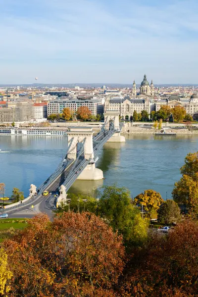 Budapeşte 'deki Tuna Nehri' ni kapsayan İkonik Zincir Köprüsü. Canlı sonbahar renkleri ve tarihi mimari Macaristan 'ın başkentinde pitoresk bir kent manzarası yaratıyor.