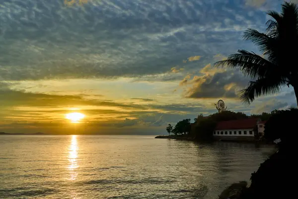 Sakin bir günbatımı, güneş sakin sulara batarken sıcak renklerle gökyüzünü boyar. Wat Phra Yai tapınağı ve palmiye ağaçları doğanın güzelliğini yansıtan pitoresk bir manzara yaratır. Kıyı manzarası ve rahatlama için ideal.