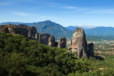 Yunanistan 'da Meteora' nın çarpıcı kaya oluşumları yemyeşil alanların üzerinde belirgin bir şekilde yükseliyor ve kayalıklara tünemiş antik manastırları sergiliyor. Nefes kesici manzara dağları ve vadileri barındırıyor, dünyanın dört bir yanından ziyaretçiler geliyor..