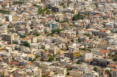 Bu hava görüntüsünde Yunanistan 'ın Argos kentindeki çeşitli konut binalarıyla dolu yoğun bir kent alanı yer alıyor. Planda, kentin canlı toplumunu yansıtan çatılar, yeşillik ve mimari tarzların bir karışımı yer alıyor..