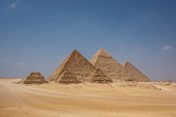 Giza 'nın Büyük Piramitleri kumlu arazide görkemli bir şekilde duruyor, antik Mısır mimarisini sergiliyor. Bu ikonik yapılar, dünyanın en büyük uygarlıklarından birinin tarihini ve mühendislik maharetini vurguluyor..