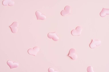 Background pattern pink heart on peach colored paper.