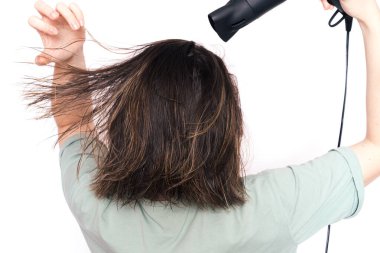Lady drying her hair against white background.