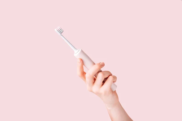 Elektrische Tandenborstel Van Roze Kleur Vrouwelijke Hand Tegen Roze Achtergrond — Stockfoto
