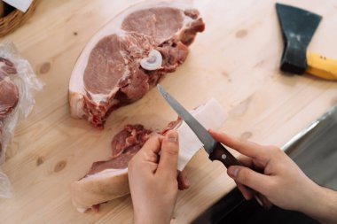 Bir adam domuz derisini bıçakla kesiyor..