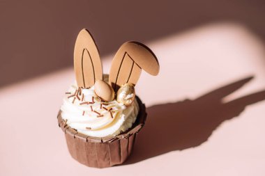 Pembe arka planda tavşan kulaklı Paskalya keki..