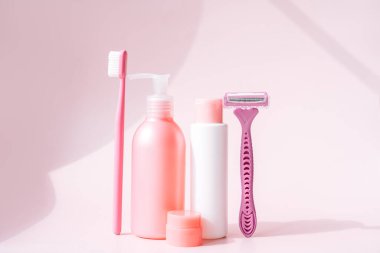 Pembe arka plana karşı pembe renkli kadın hijyeni ve sabun ürünleri.