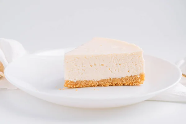 白い背景にプレート上の白い古典的なチーズケーキとナプキン — ストック写真