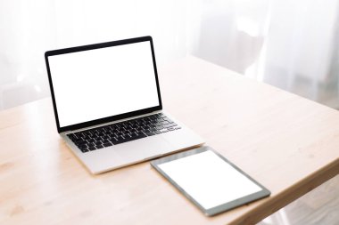 Tahta masadaki yazı veya reklam için boş ekranları olan dizüstü bilgisayar ve tablet.