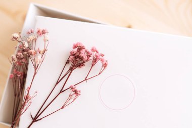 Tahta bir masanın üzerinde yazılı olmayan beyaz bir kutu..